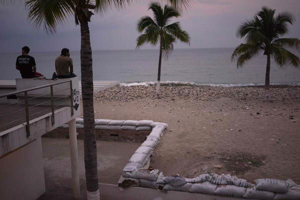 Two men sit out by the beach as hurricane Patricia nears in the Pacific resort city of Puerto Vallarta, Mexico, Thursday, Oct. 22, 2015. <span class=meta>AP Photo/ Cesar Rodriguez</span>