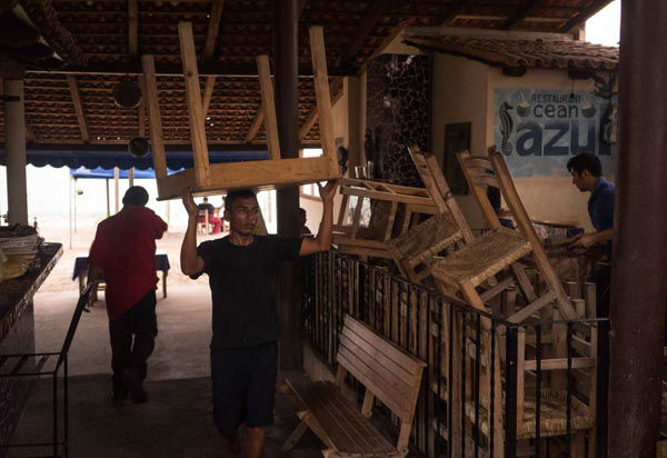 A worker carries a table at a seaside restaurant preparing for the arrival of hurricane Patricia in the Pacific resort city of Puerto Vallarta, Mexico, Thursday, Oct. 22, 2015. <span class=meta>AP Photo/ Cesar Rodriguez</span>