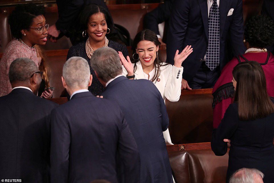 Meet the star: Alexandria Ocasio-Cortez mingles with other Democrats on the floor of the House as Nancy Pelosi gets ready to become speaker