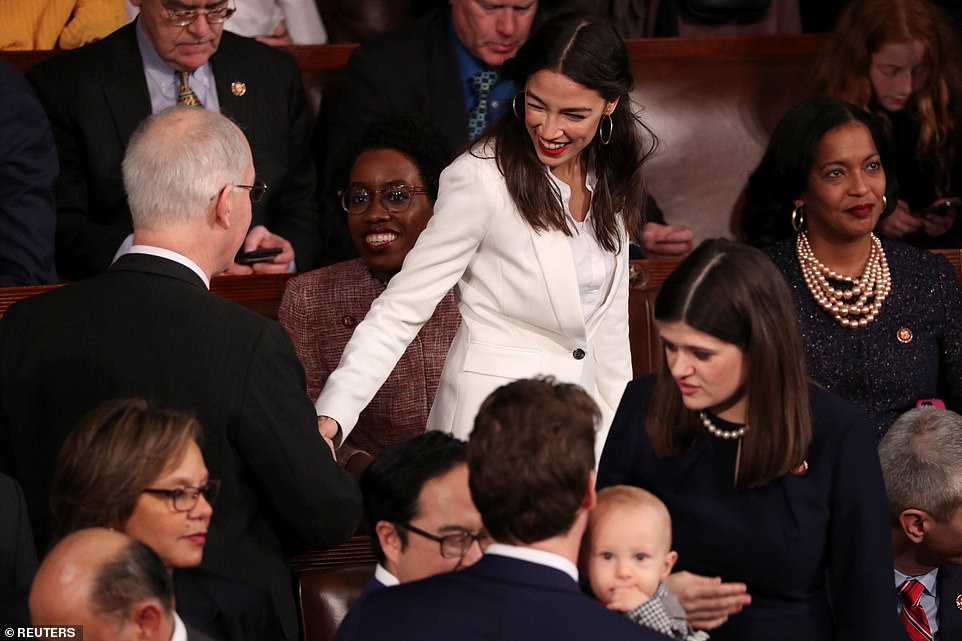 Nice to meet you: Alexandra Ocasio-Cortez greets another member of Congress as she prepares for her first act as a member of the House of Representatives